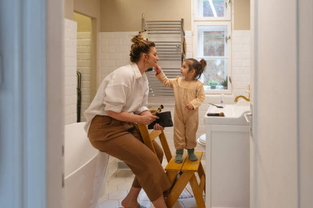 Child putting makeup on her mother in the bathroom