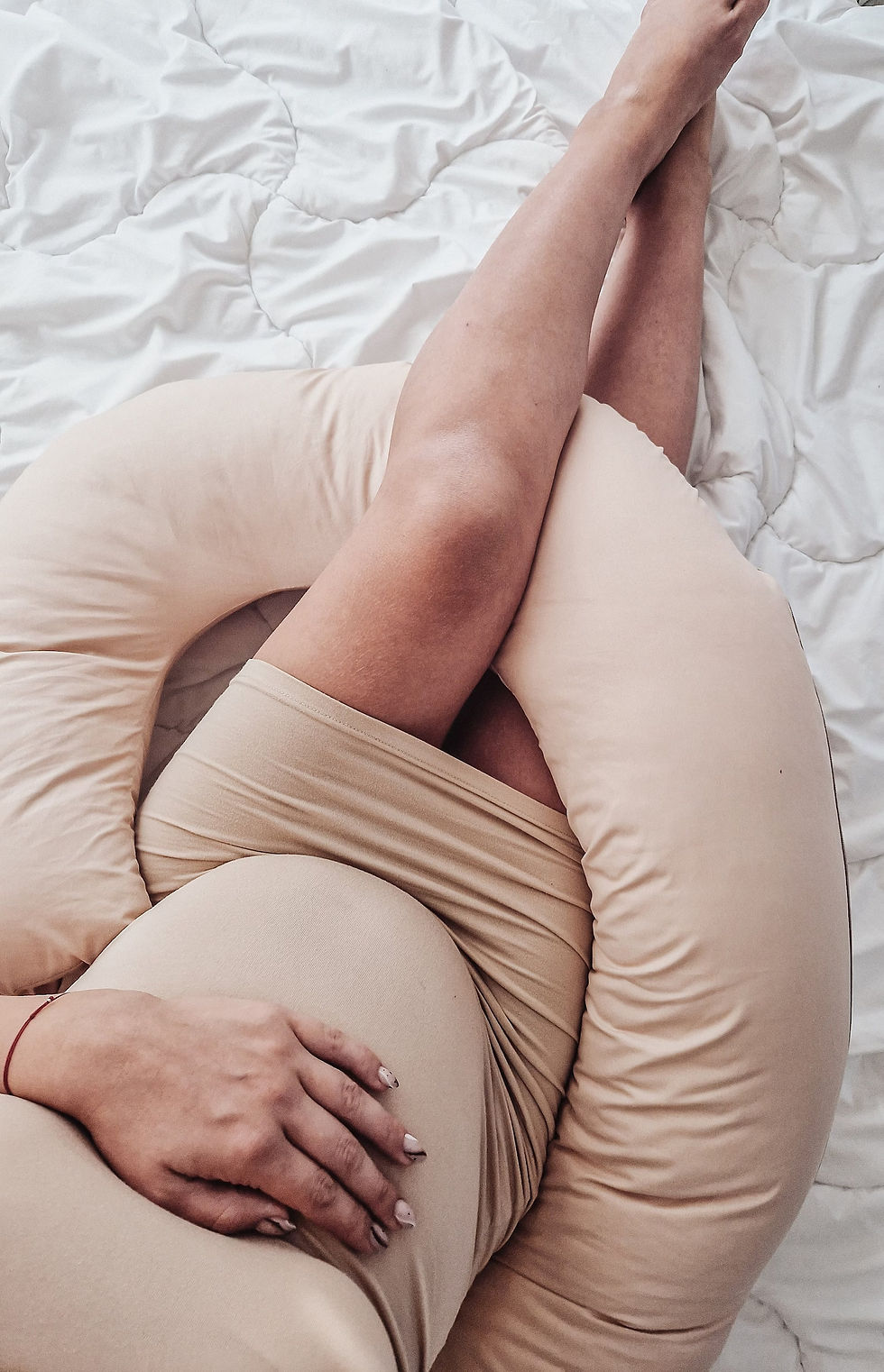 Pregnant woman using a body pillow