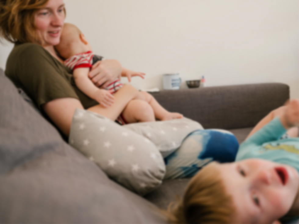 Mom sitting on the couch with her two kids