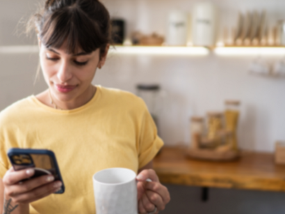 Woman with coffee mug staring at her phone