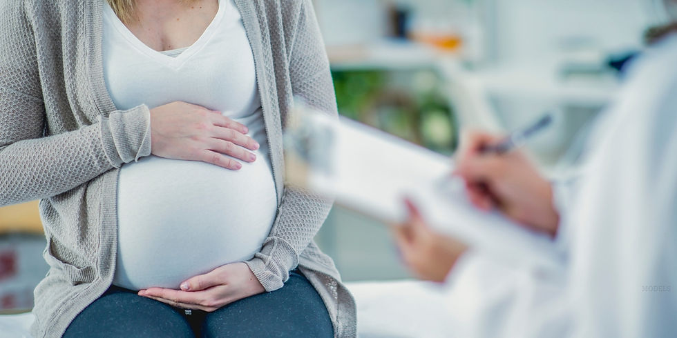 Two sets of hands resting on a pregnant woman's stomach.