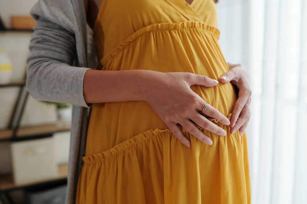 A pregnant woman holds her stomach.