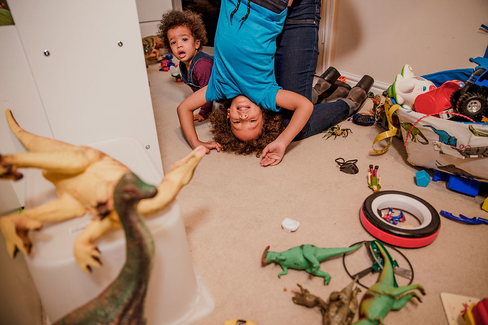Two young boys playing in a room filled with toys
