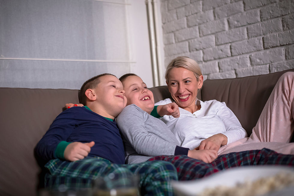 Woman smiling on the couch with her two boys