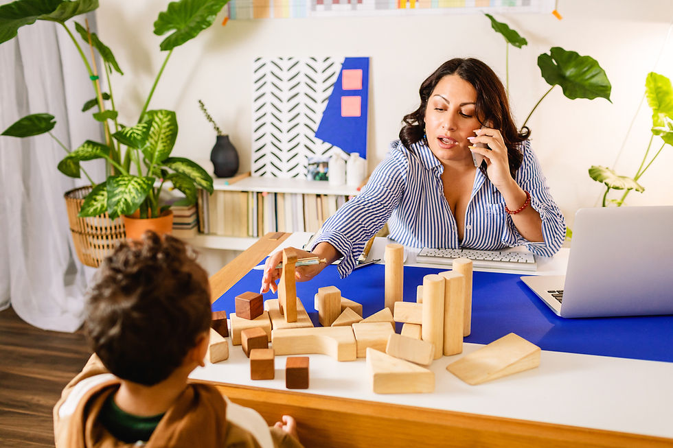 Mother talking on the phone while playing blocks with her child