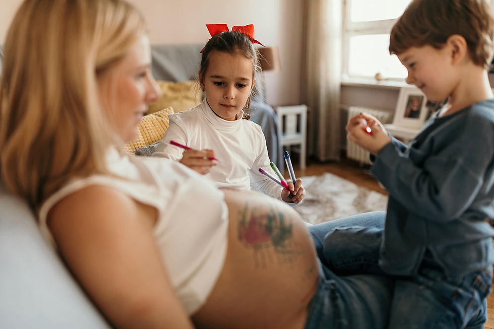 Two kids drawing on Mom's pregnant belly