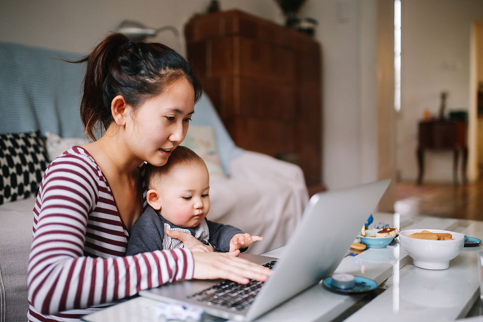Asian woman working on her laptop with baby on her lap