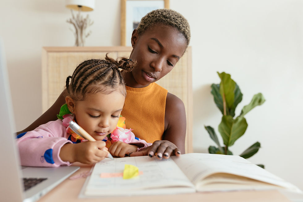 Young child writing in a notebook while she sits on her Mom's lap