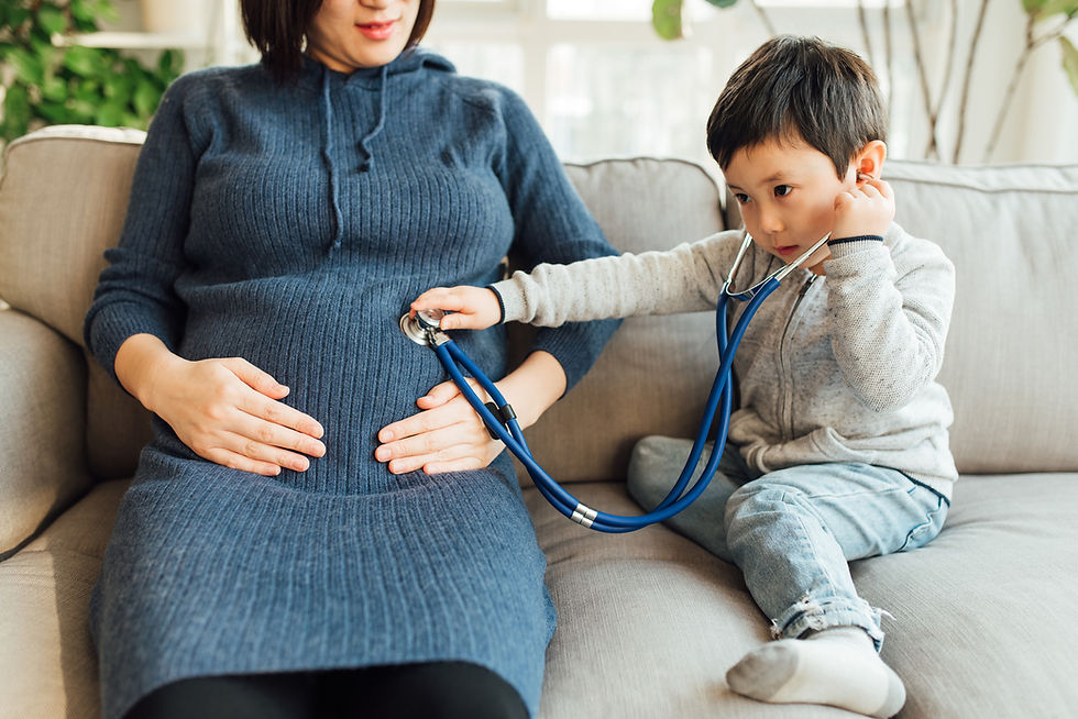 Toddler using a stethoscope on his expecting mother's belly