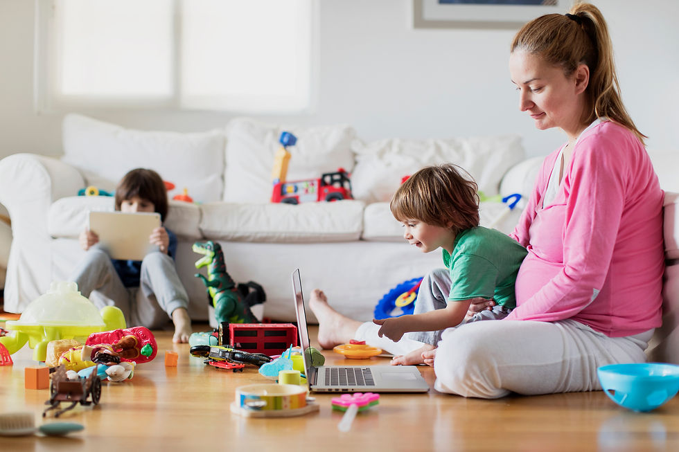 Pregnant Mom sitting with her kids in a room full of toys
